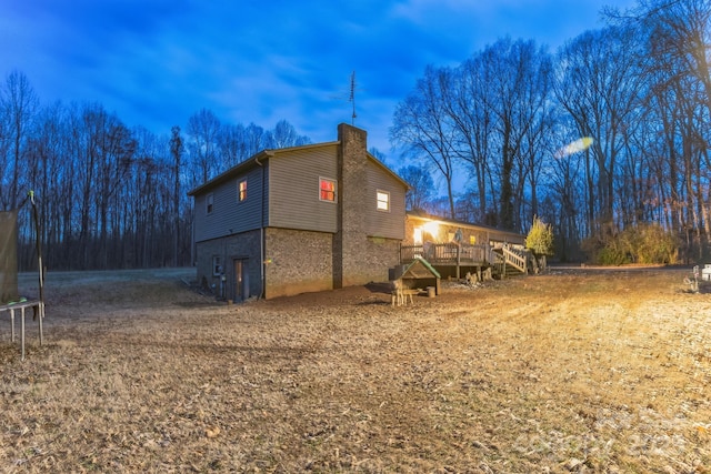 view of side of property featuring a deck and a trampoline