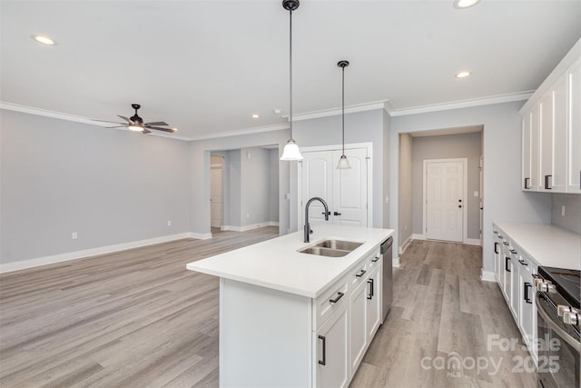 kitchen featuring sink, white cabinetry, a center island with sink, pendant lighting, and stainless steel appliances