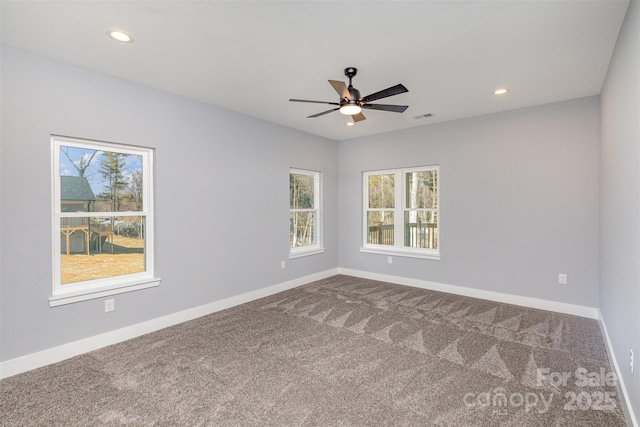 unfurnished room featuring baseboards, dark colored carpet, ceiling fan, and plenty of natural light