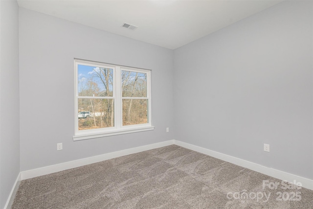 spare room with baseboards, visible vents, and carpet floors
