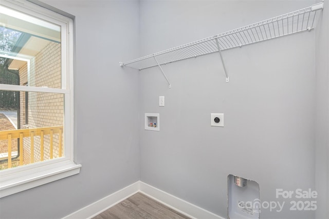 clothes washing area with hookup for an electric dryer, washer hookup, baseboards, wood finished floors, and laundry area