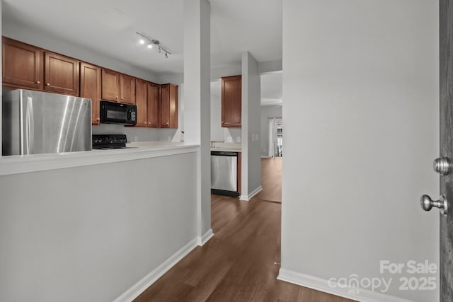 kitchen featuring track lighting, black appliances, and dark hardwood / wood-style floors