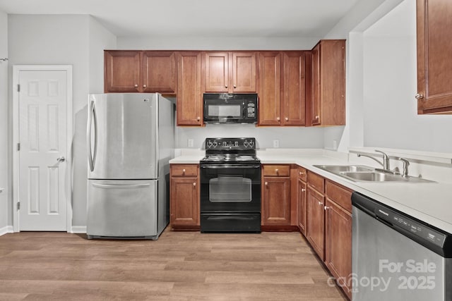 kitchen featuring light hardwood / wood-style floors, sink, and black appliances