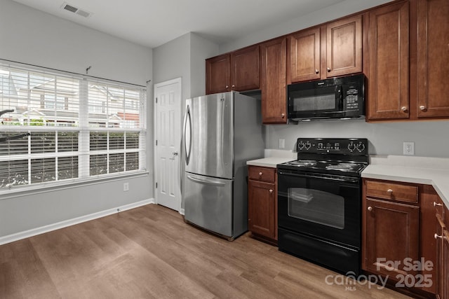 kitchen featuring light wood-type flooring and black appliances