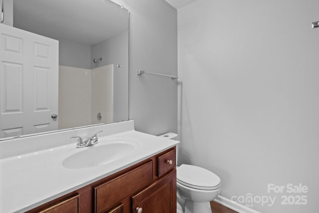 bathroom featuring vanity, toilet, and a shower