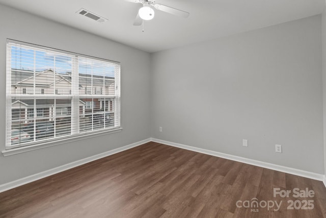 empty room featuring ceiling fan and dark hardwood / wood-style floors