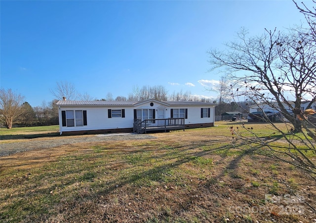 view of front of property with a wooden deck and a front lawn