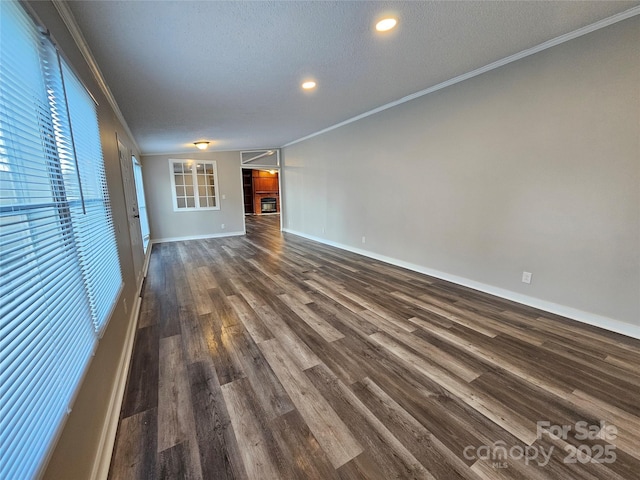 unfurnished living room featuring crown molding, dark wood-type flooring, and a textured ceiling