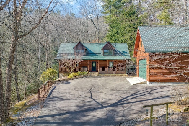 log-style house with a garage and covered porch