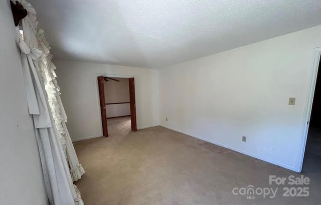 empty room featuring a textured ceiling and carpet