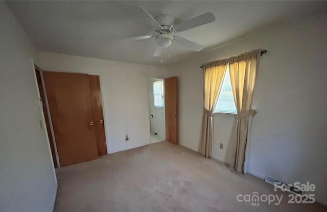 empty room with light carpet and ceiling fan