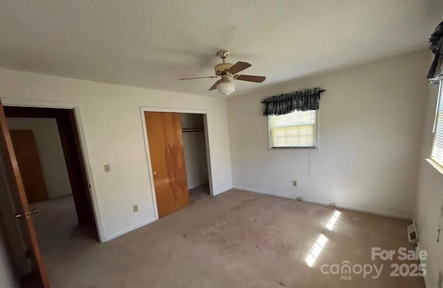 unfurnished bedroom with a textured ceiling, a closet, and ceiling fan