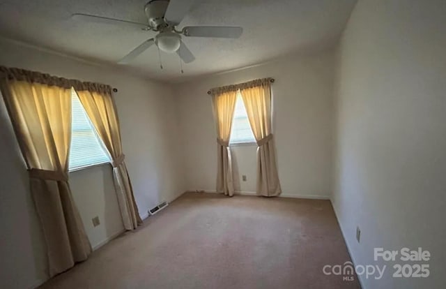 spare room featuring light carpet and ceiling fan