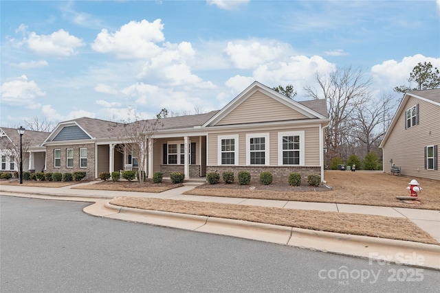 view of front of home with brick siding and a porch