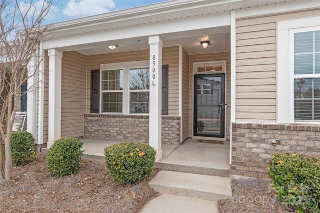 entrance to property with brick siding and covered porch