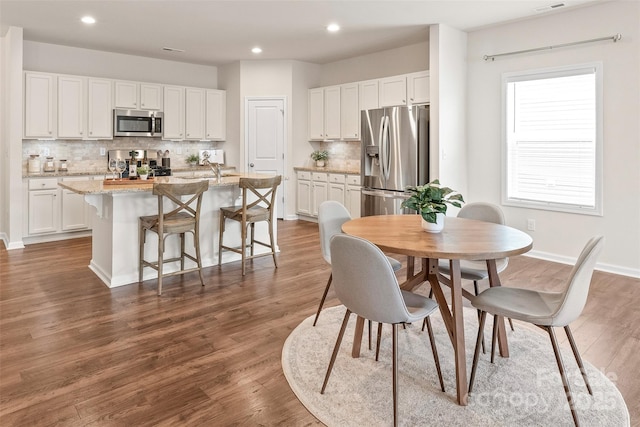 dining room featuring recessed lighting, baseboards, visible vents, and dark wood-type flooring