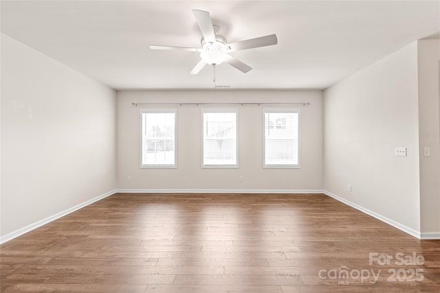 spare room with plenty of natural light, hardwood / wood-style flooring, and ceiling fan