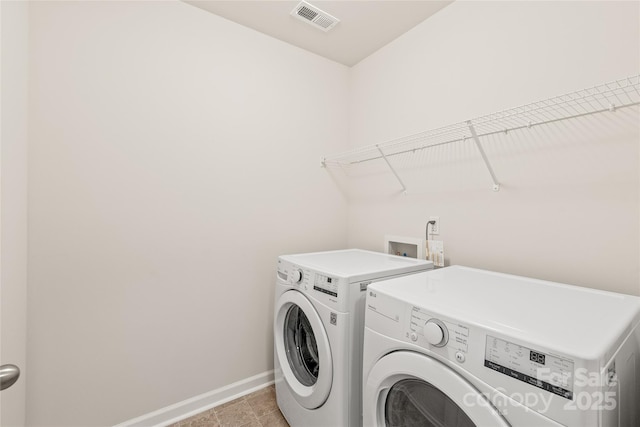 laundry area with washer and dryer, baseboards, visible vents, and laundry area