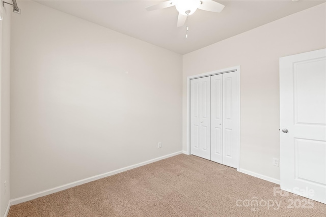 unfurnished bedroom featuring baseboards, a closet, light colored carpet, and ceiling fan