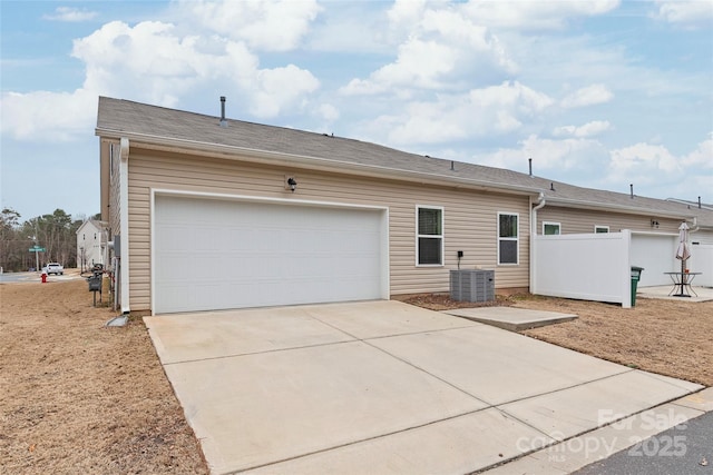 view of home's exterior featuring concrete driveway, an attached garage, and cooling unit