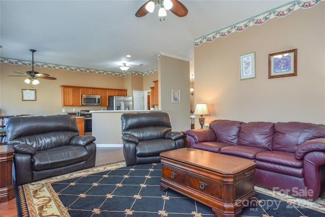 living room featuring ceiling fan and dark hardwood / wood-style flooring