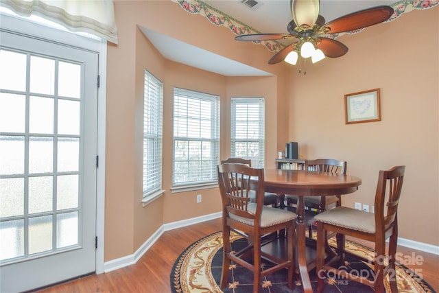 dining space featuring wood-type flooring and ceiling fan