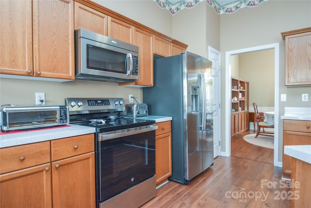 kitchen featuring hardwood / wood-style flooring and stainless steel appliances