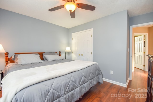 bedroom with ceiling fan, dark hardwood / wood-style flooring, and a closet