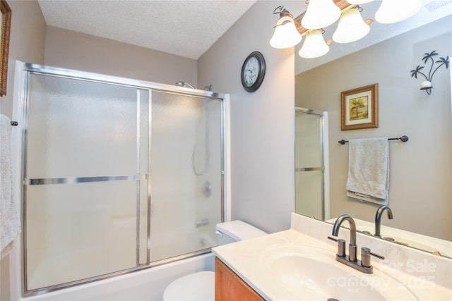 full bathroom with toilet, a textured ceiling, vanity, a notable chandelier, and enclosed tub / shower combo