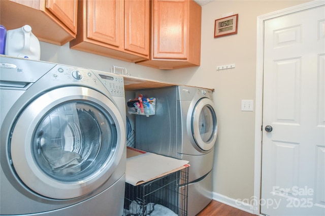 laundry area with cabinets, wood-type flooring, and washing machine and clothes dryer