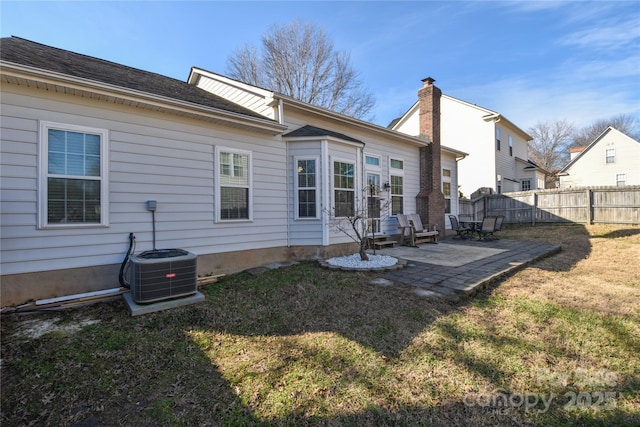 back of house featuring central AC unit, a lawn, and a patio area