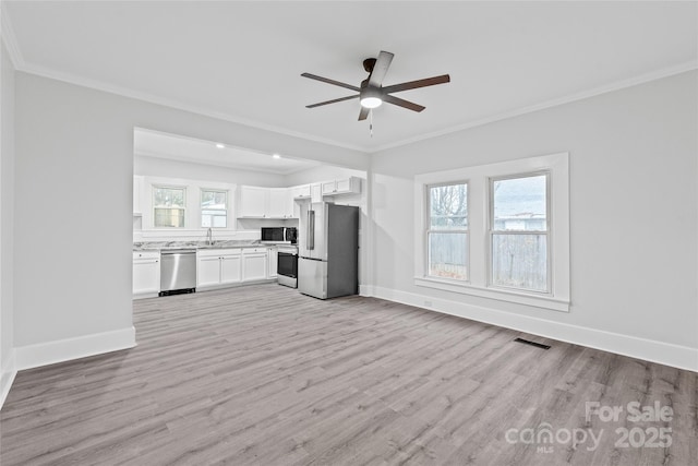 kitchen with crown molding, appliances with stainless steel finishes, sink, and light wood-type flooring