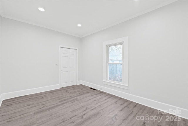 empty room with hardwood / wood-style flooring and ornamental molding