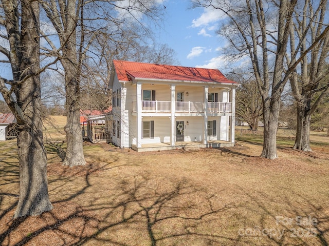 view of front facade with a porch, metal roof, and a balcony