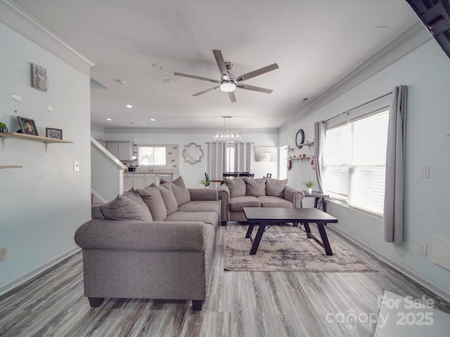 living room with wood-type flooring, ornamental molding, and ceiling fan