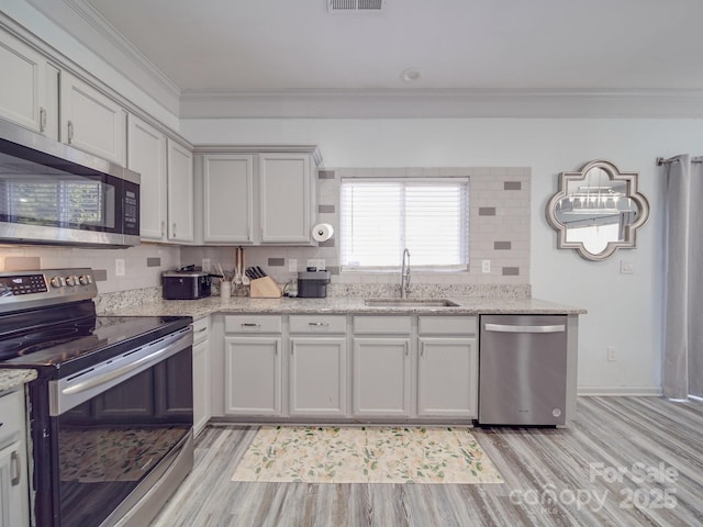 kitchen featuring crown molding, appliances with stainless steel finishes, sink, and backsplash