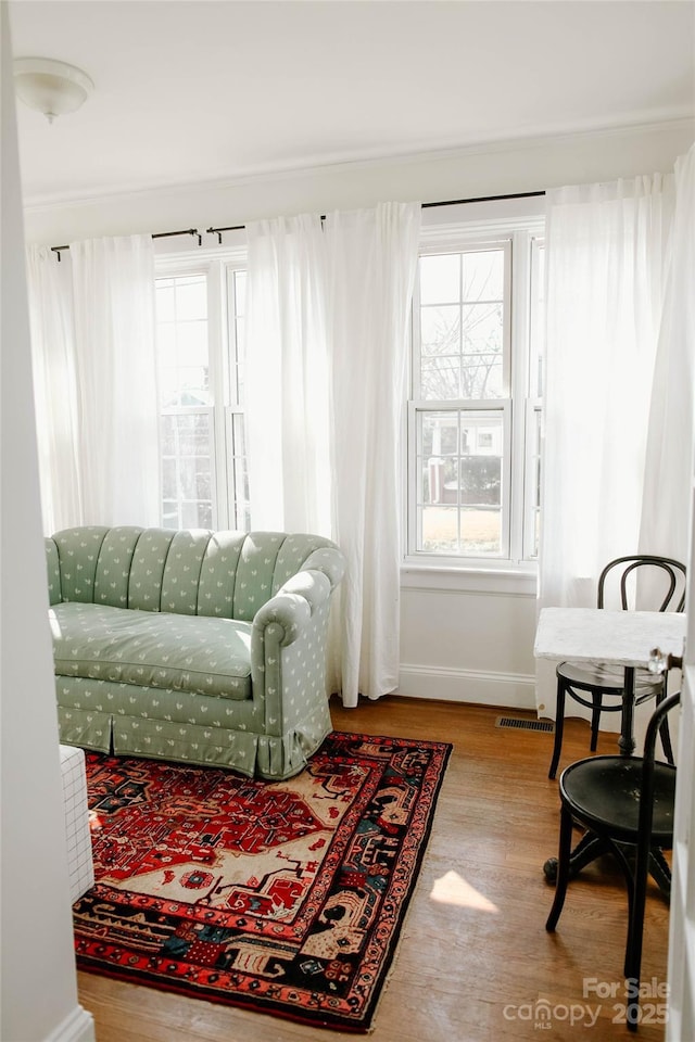 interior space featuring a healthy amount of sunlight, visible vents, baseboards, and wood finished floors