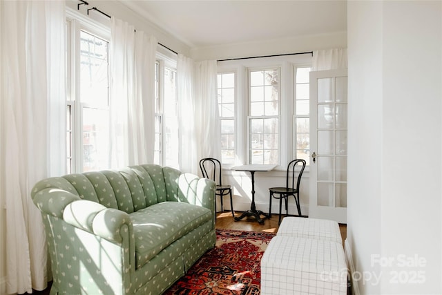 living area with baseboards and wood finished floors