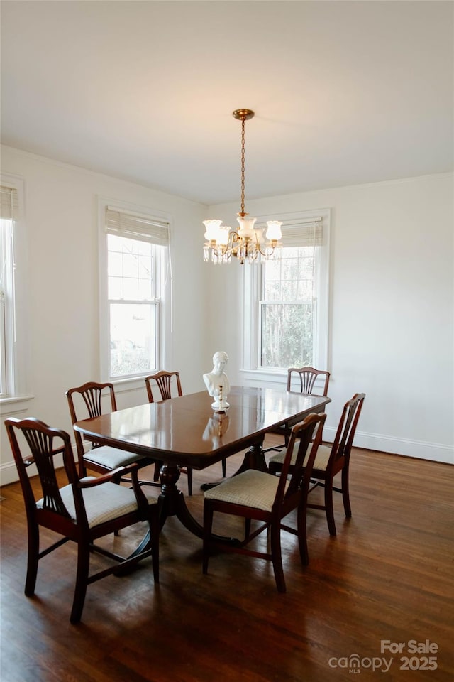 dining room with dark wood-style flooring, a notable chandelier, and baseboards