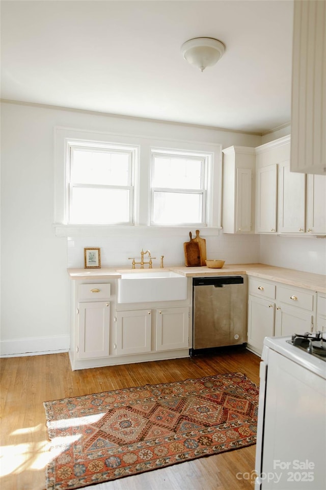 kitchen with light wood-style flooring, a sink, white range, and stainless steel dishwasher