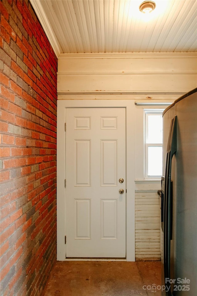 entryway featuring brick wall