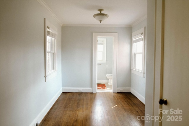 interior space featuring ornamental molding, dark wood-style flooring, and baseboards