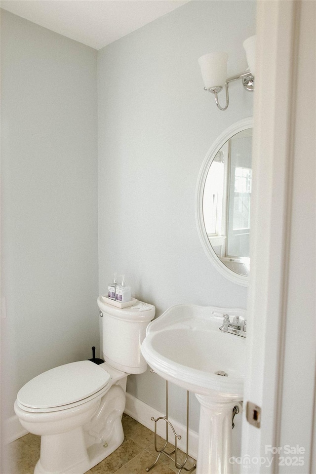 bathroom featuring toilet, tile patterned flooring, and baseboards