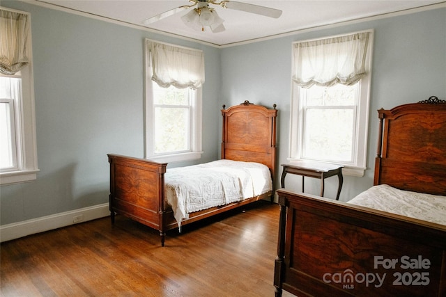 bedroom featuring a ceiling fan, baseboards, dark wood-type flooring, and ornamental molding