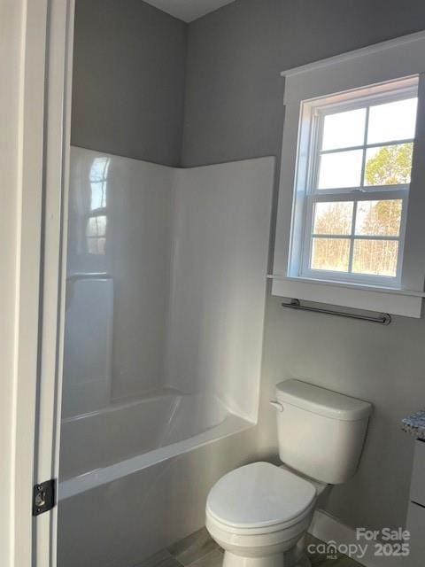 bathroom featuring shower / tub combination and toilet