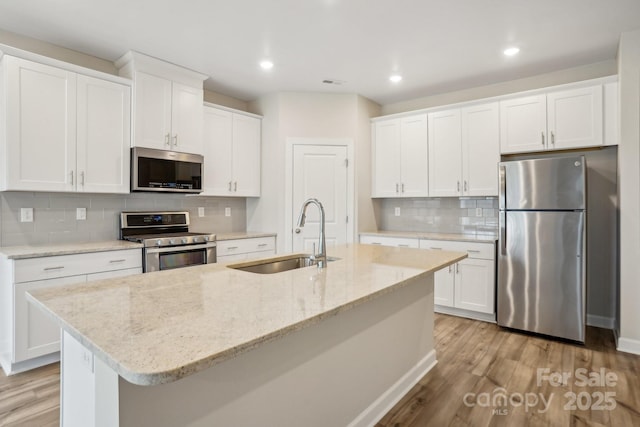 kitchen featuring white cabinetry, sink, an island with sink, and appliances with stainless steel finishes