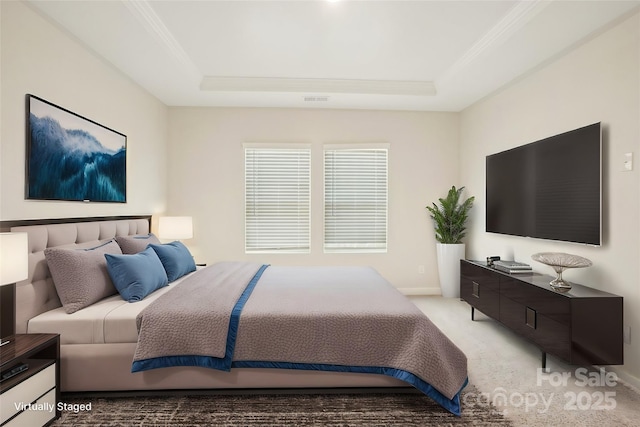 carpeted bedroom with ornamental molding and a tray ceiling