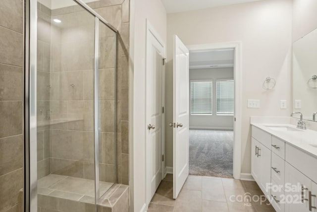 bathroom featuring vanity, a shower with shower door, and tile patterned floors