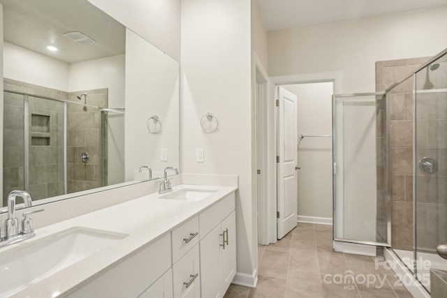 bathroom with tile patterned flooring, vanity, and a shower with shower door