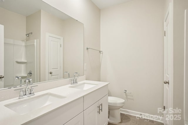 bathroom featuring vanity, tile patterned flooring, toilet, and walk in shower